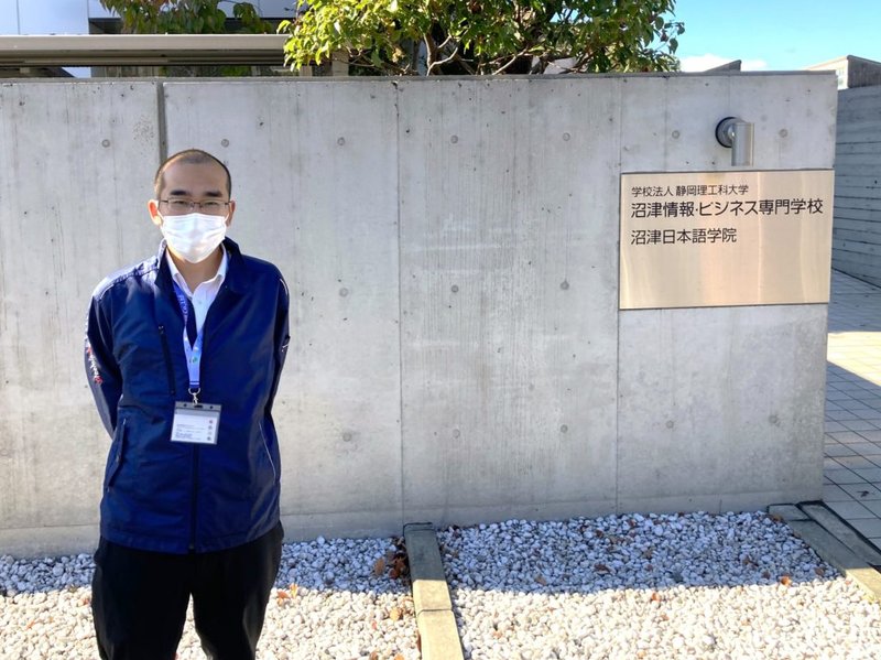 沼津情報・ビジネス専門学校様の入口に立つ講師の立花の写真
